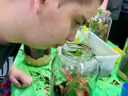 Uczeń patrzy w słoik z rośliną