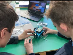 Uczniowie z robotem i laptopem