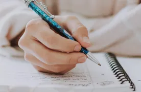 Osoba pisze długopisem