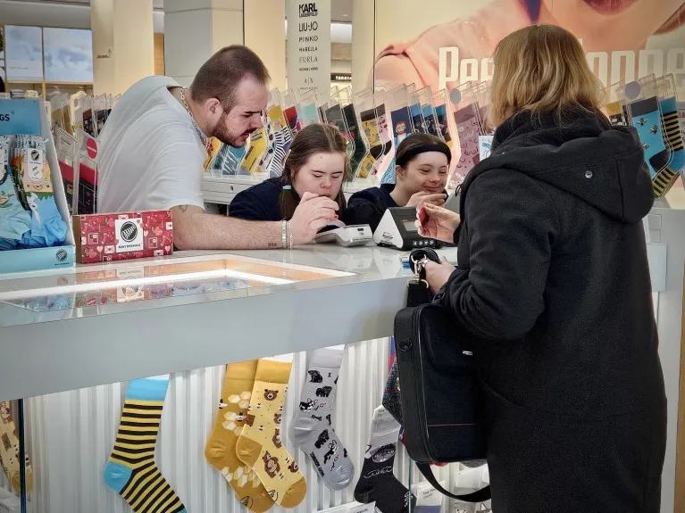 Dwie uczennice Szkoły Specjalnej Przysposabiającej do Pracy nr 3 sprzedają skarpetki na stoisku w centrum handlowym podczas zajęć praktycznych.